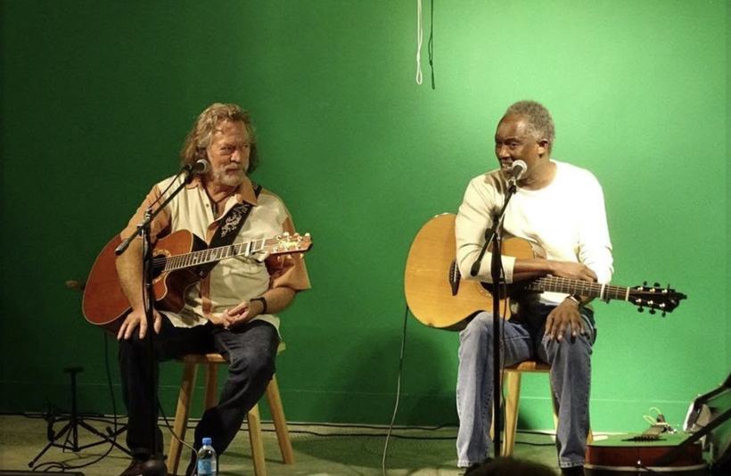 Two guitars, one green wall